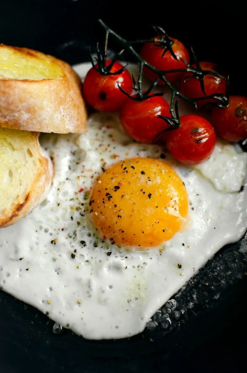 plate with cooked egg and tomatoes